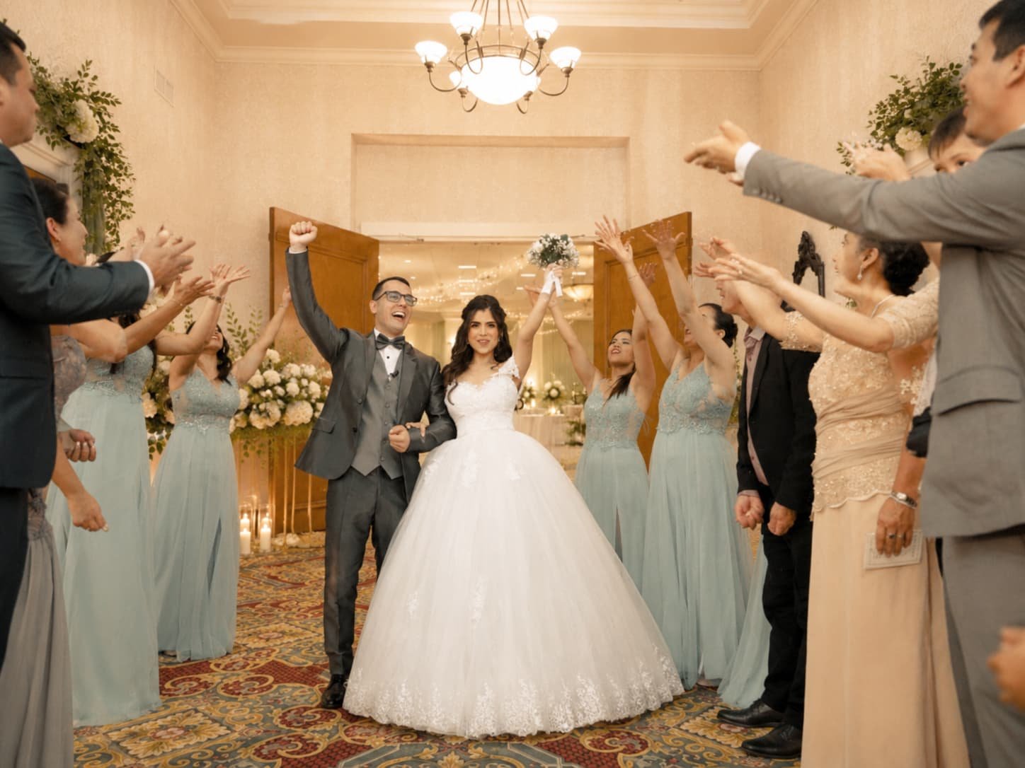 Newlyweds celebrate joyfully at Quaker Station, surrounded by cheering guests in elegant attire.